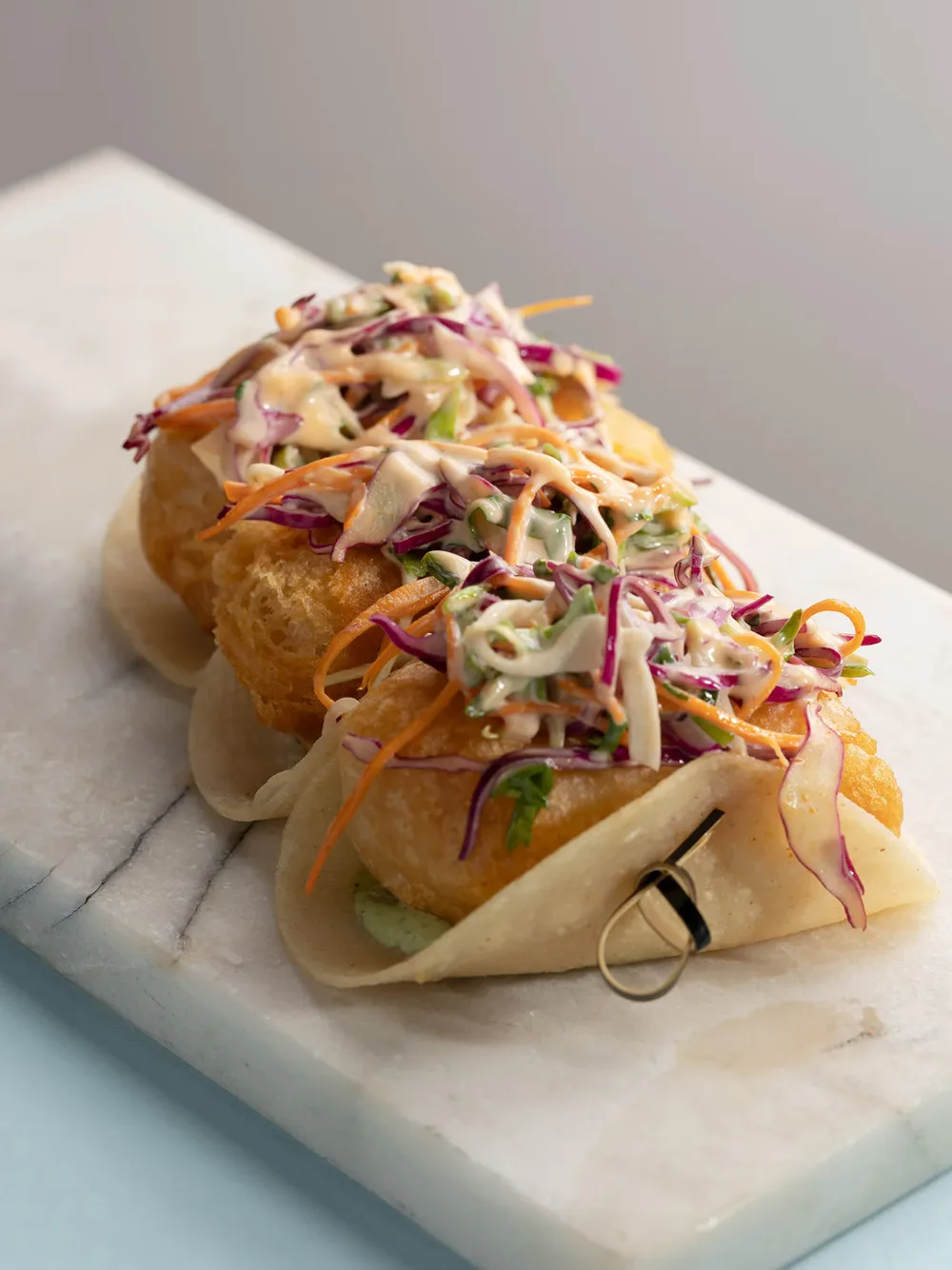 Fish tacos with red cabbage slaw and avocado crema